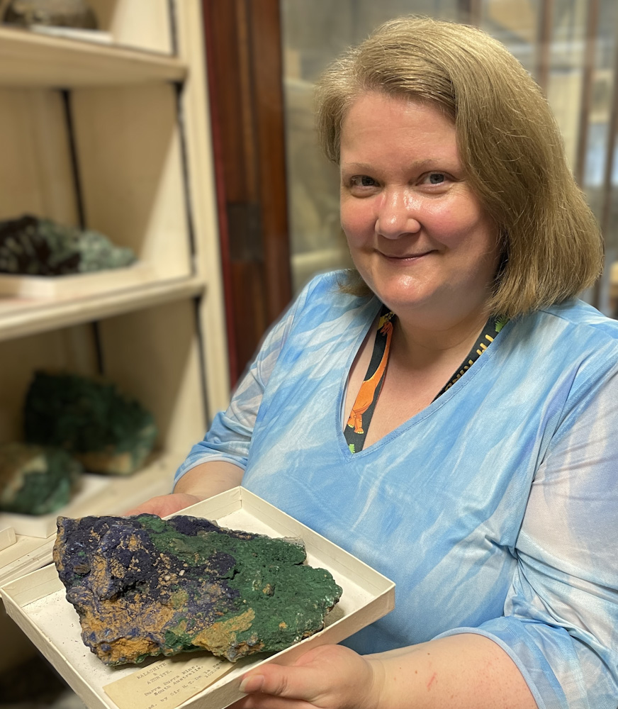 Committee member Karen Bell holding a specimen of malachite and azurite